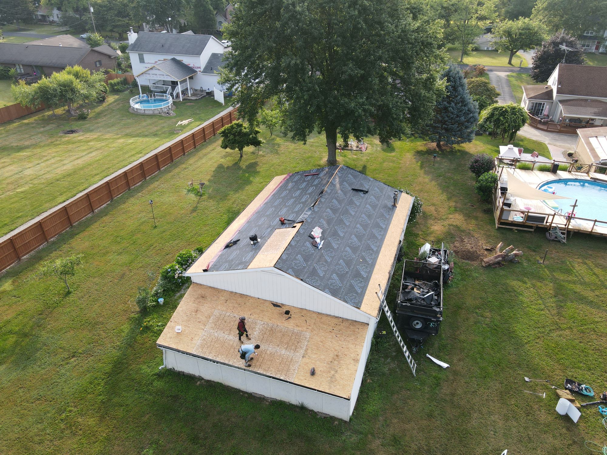 Aerial view of a crew on a roof tear-off, the deck exposed