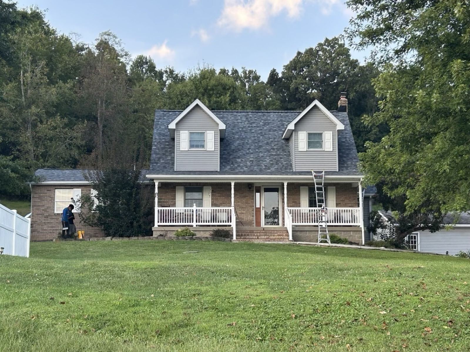 Cape Cod home with a crew ladder against the porch roof